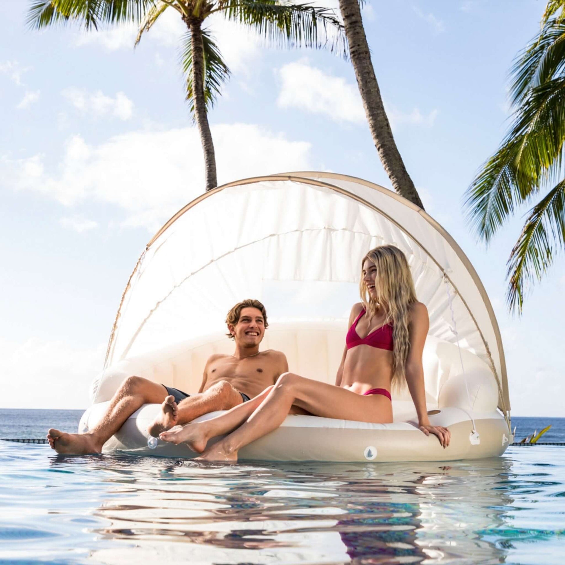 Couple relaxing on INTEX Canopy Island Inflatable Pool Float in the water, SKU 58292EP, perfect for SOS Pool experiences.