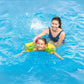 Child enjoys swimming with Intex Dinosaur Arm Bands in a pool, supervised by an adult - part number 32132J