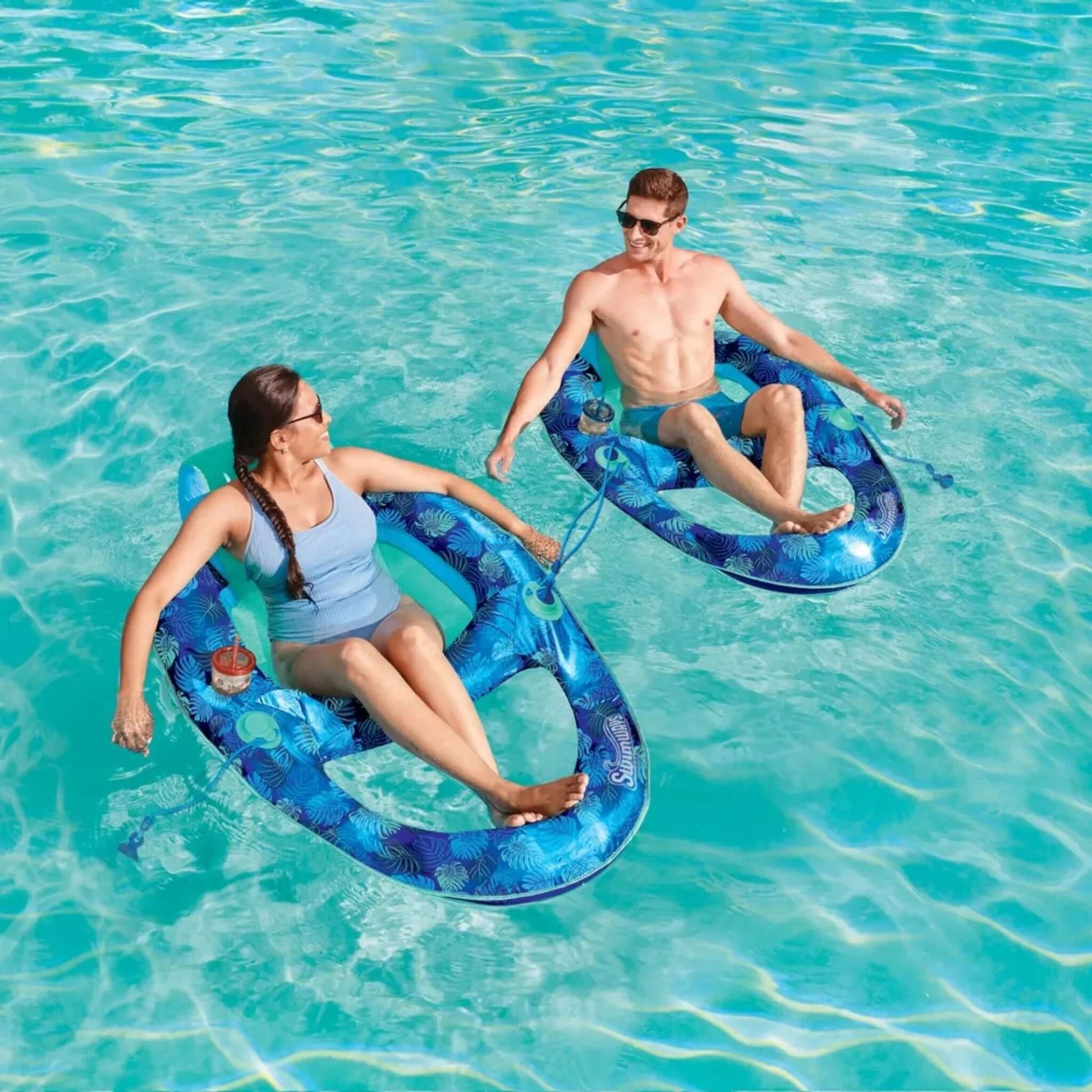 Two people relaxing on SwimWays Elite Spring Float Recliner in pool, enjoying summer vibes, SKU 6069308.