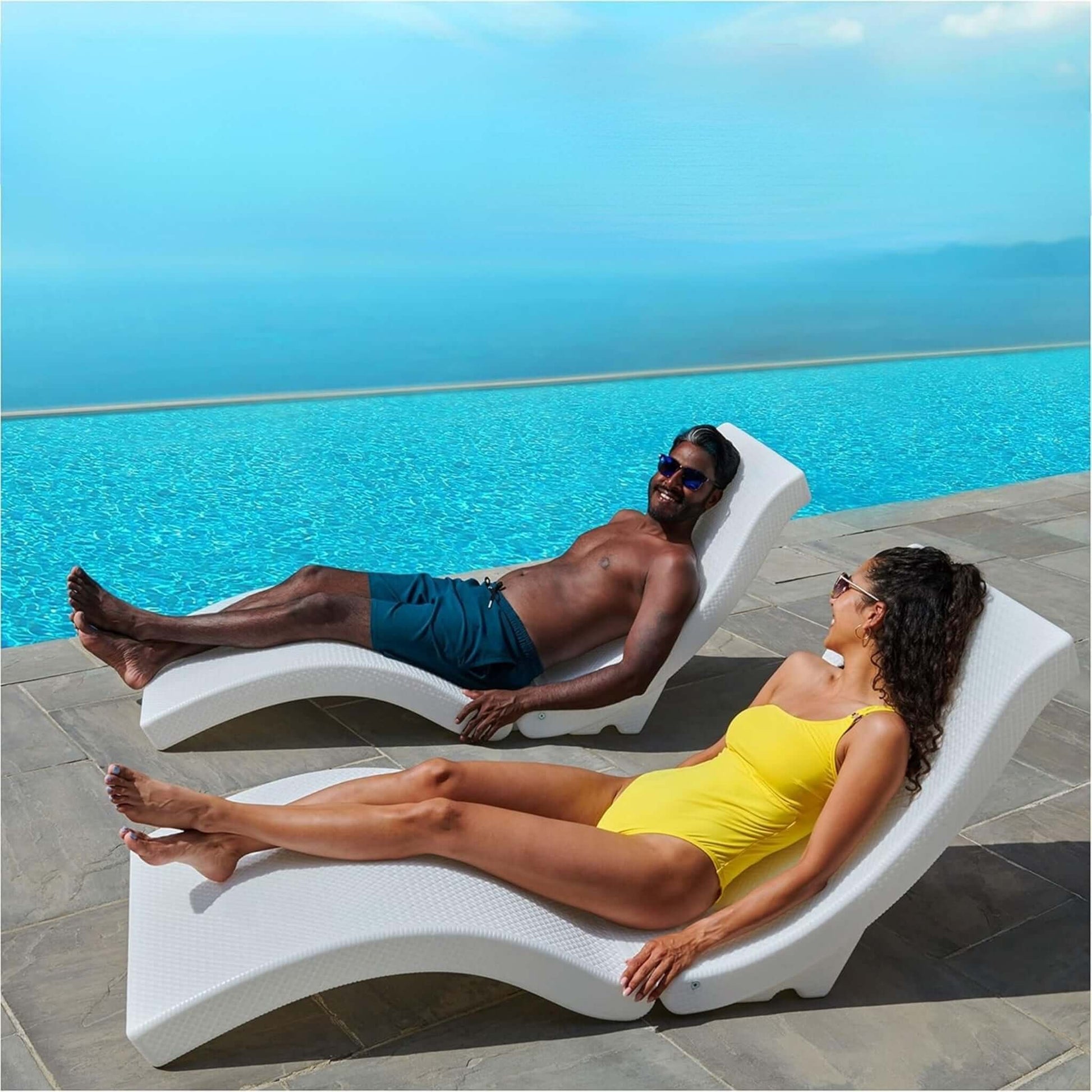 Two people lounging on SwimWays Terra Sol Sonoma Pool Lounge by a blue pool. SKU: SOS Pool.