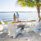Couple enjoying a beachfront view with TenJam chairs around a fire pit, ideal for relaxation by the water.